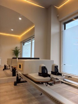 Reformer studio with warm ambient lighting, arched ceiling and large windows