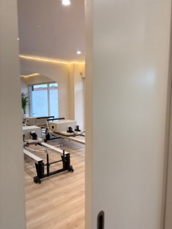 Glimpse through pocket door into the Anú reformer studio